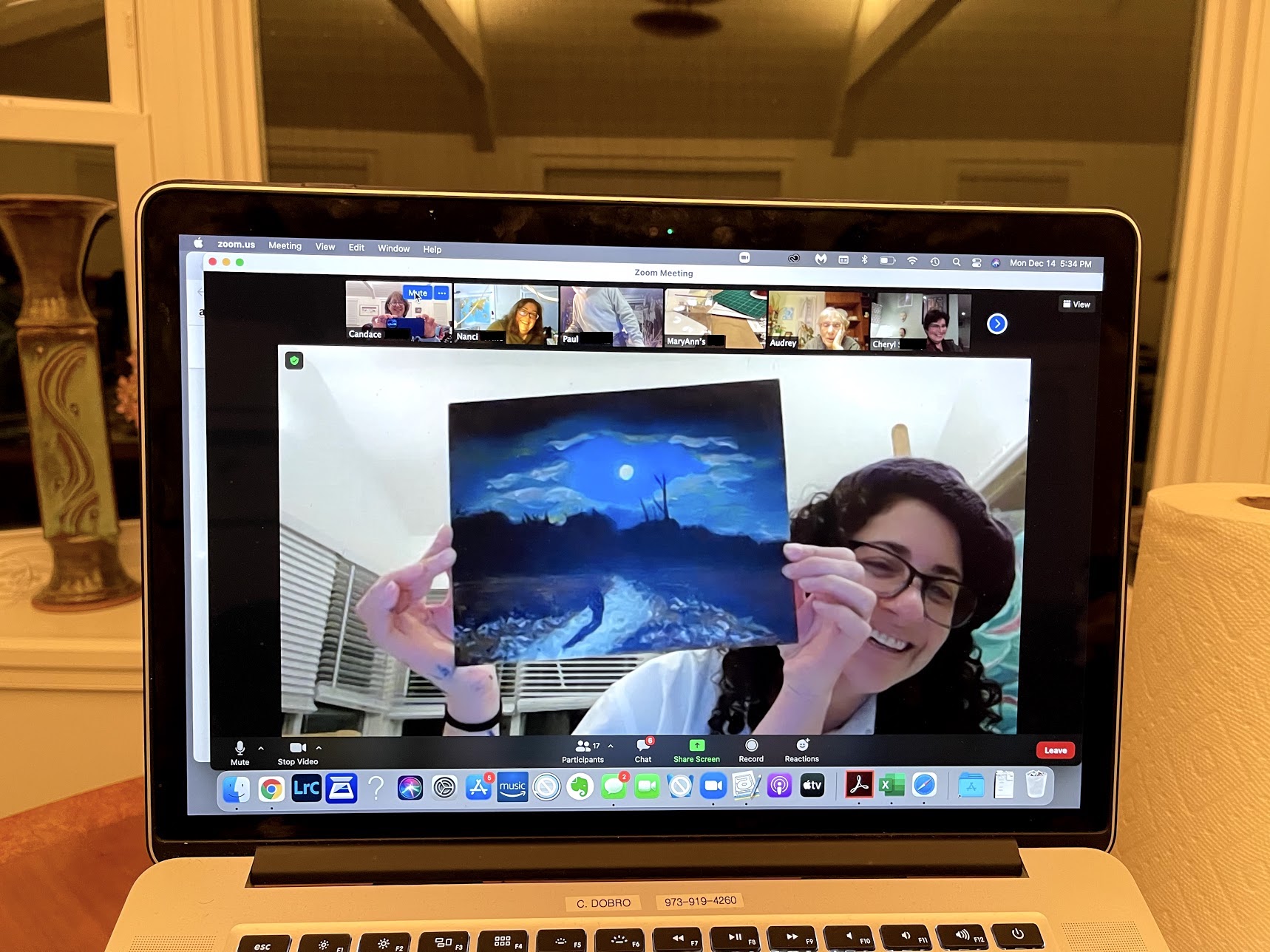 Noaa holding up a painting for Docents to see in a Zoom meeting.