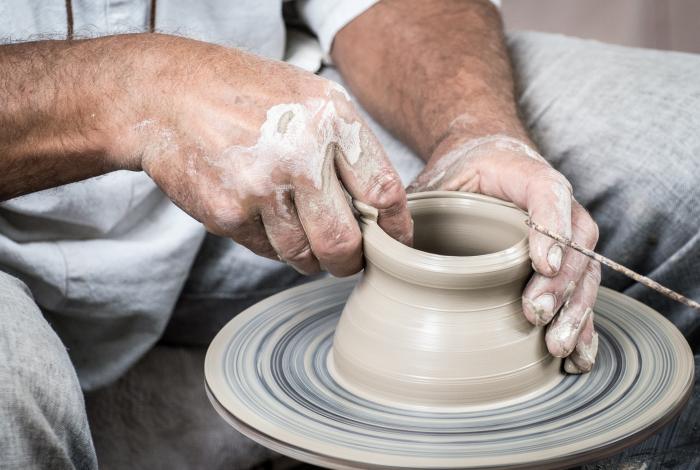 Close up of hands molding clay on a potter's wheel